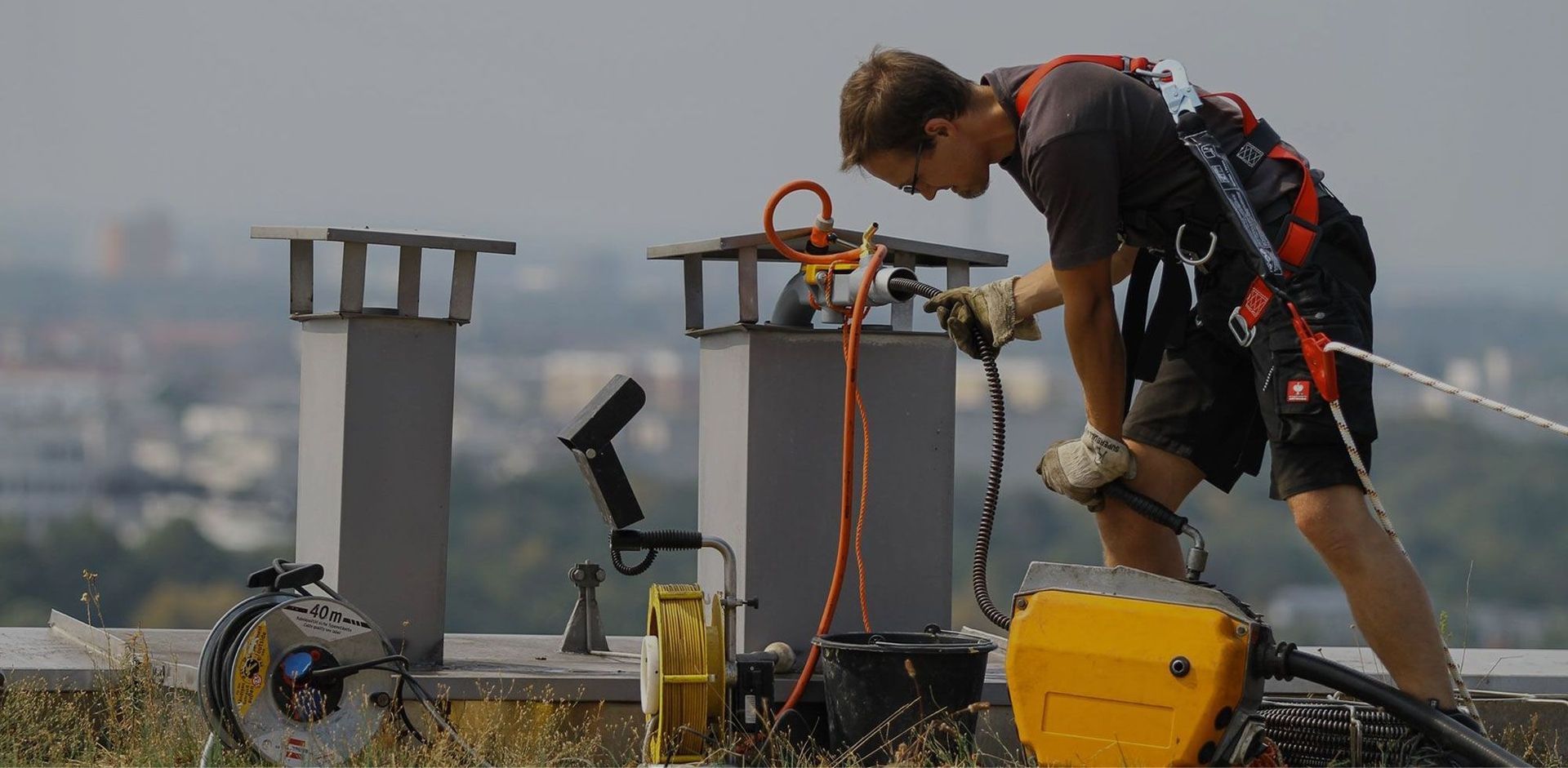 Ein Mann arbeitet auf einer Baustelle, umgeben von Baugeräten und Materialien, konzentriert auf seine Aufgabe.